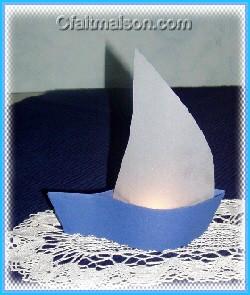 Photophore en forme de bateau avec voile en papier calque et bougie allumée