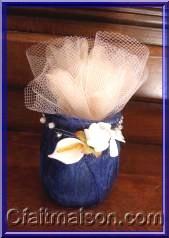Prsentation de drages dans un pot de laitage en verre haut  serviett, finition avec fleurs et un fil de fer fin garni de perles.