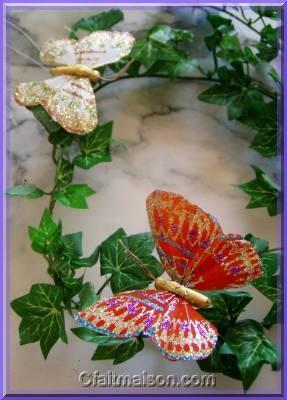 Papillon en plumes peintes et pailletes.