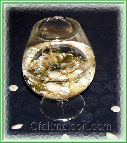 Verre de dgustation avec mini-graviers, galets, coquillages, toile de mer, vgtaux et eau.