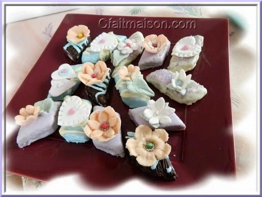 Petits fours avec dcor en pte  sucre sur couverture de chocolat ou glaage royal.