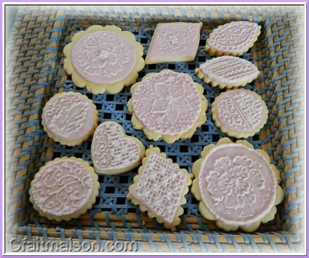 Biscuits avec glaage royal rose et dessins raliss sur ce glaage en glaage blanc.